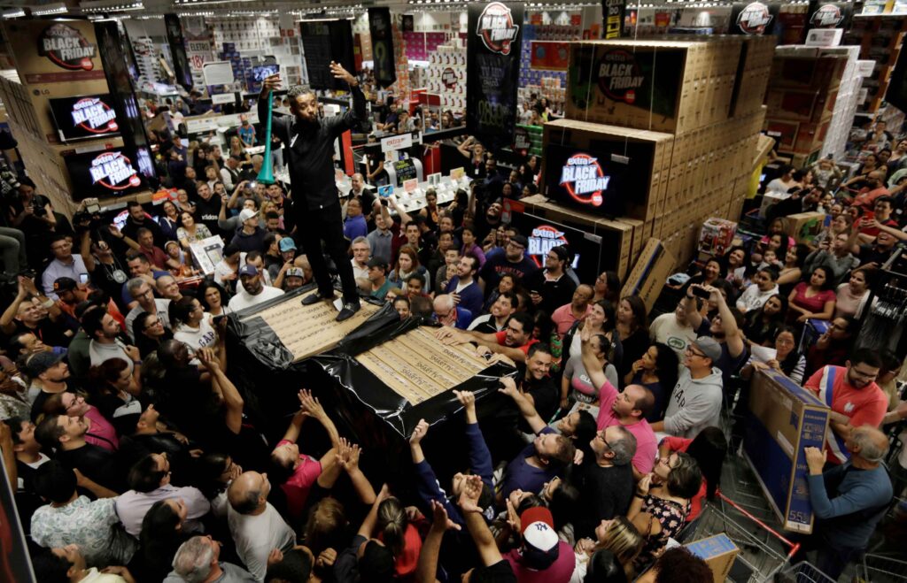 Imagem demonstrando uma loja varejista em período de Black Friday, com uma multidão de pessoas comprando